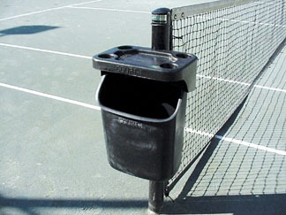 Black trash can with an ashtray mounted on a pole beside a tennis court. The setup encourages proper waste disposal during matches.