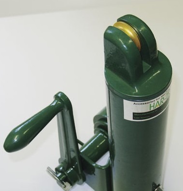 A green hydraulic hand pump with a lever, designed for various mechanical tasks. Relevant for demonstration of hydraulic equipment usage.