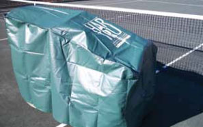 Green cover protecting tennis equipment on a court, ensuring maintenance and longevity during off-season or inclement weather.