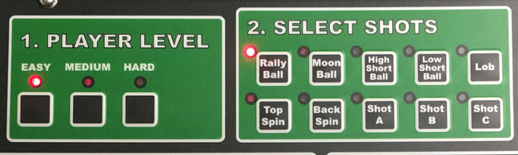 Control panel for a sports training device, featuring player level settings (Easy, Medium, Hard) and shot selections (e.g., Rally Ball, Top Spin).