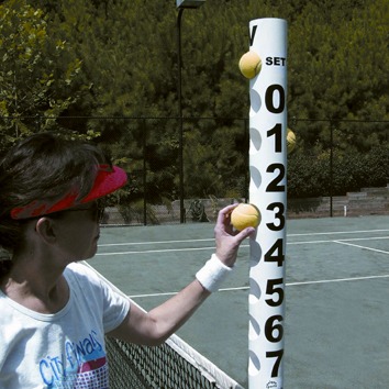 A player adjusts tennis balls on a scoring pole during a match, indicating the current set score on a sunny court.
