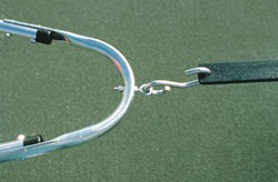 Close-up of a metal hook connecting to a gym apparatus, highlighting the mechanism used for attachment on a synthetic surface.